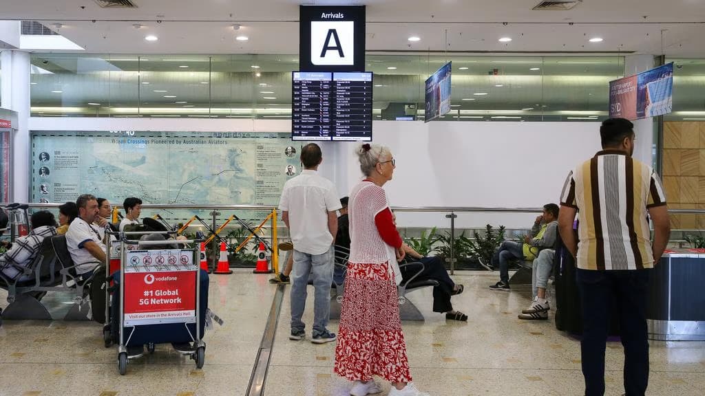 Travellers walking through an airport terminal with luggage