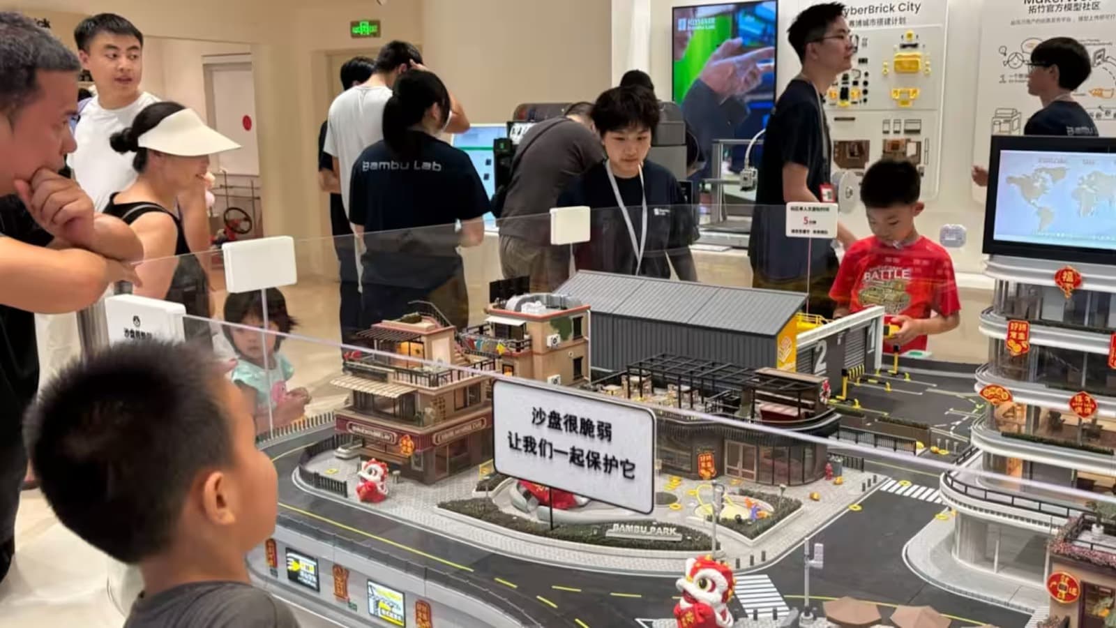 Children and families look at a detailed 3D printed model city on display at a Bambu Lab store in China