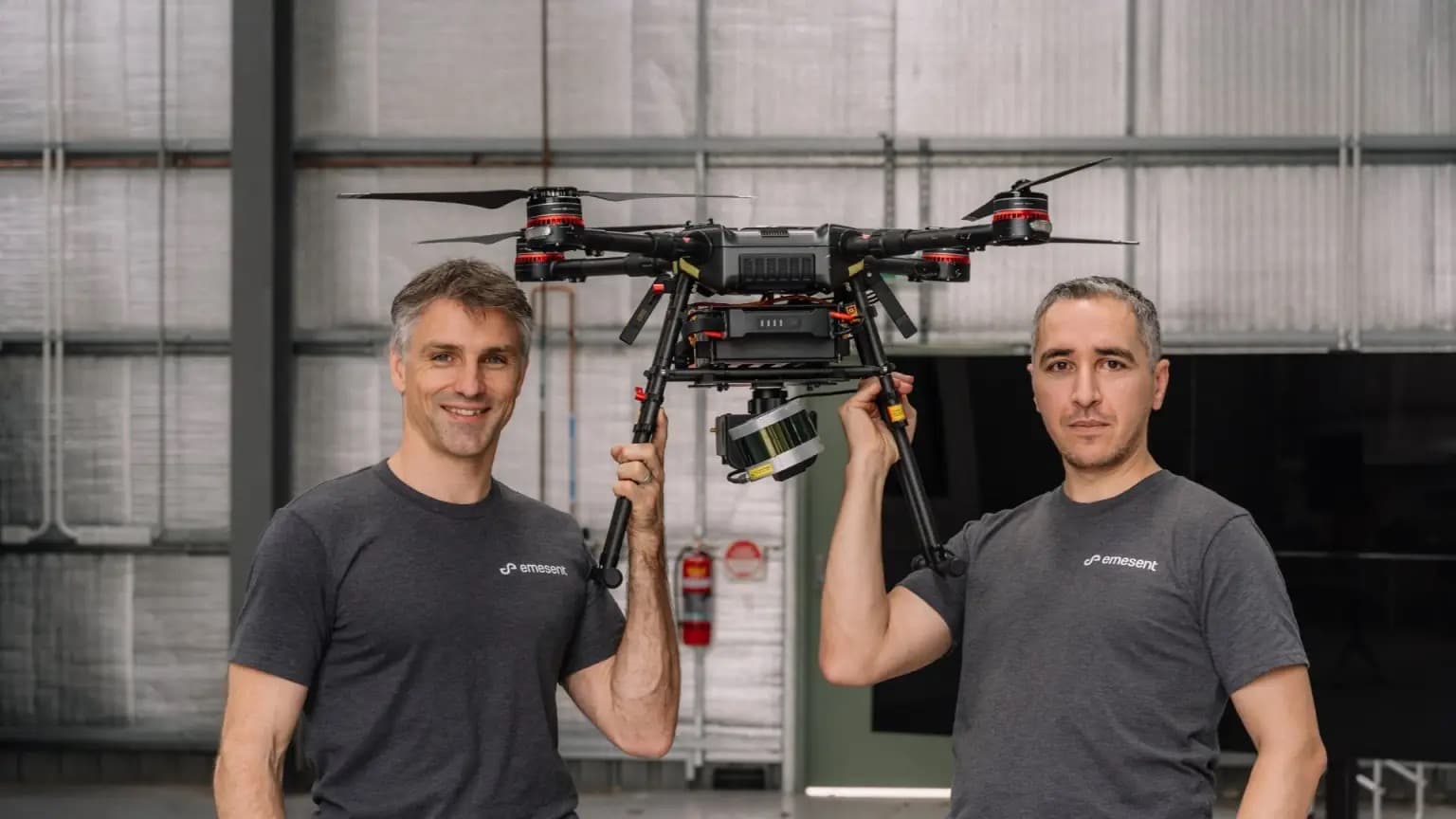 Two Emesent co-founders holding a drone equipped with LiDAR mapping equipment