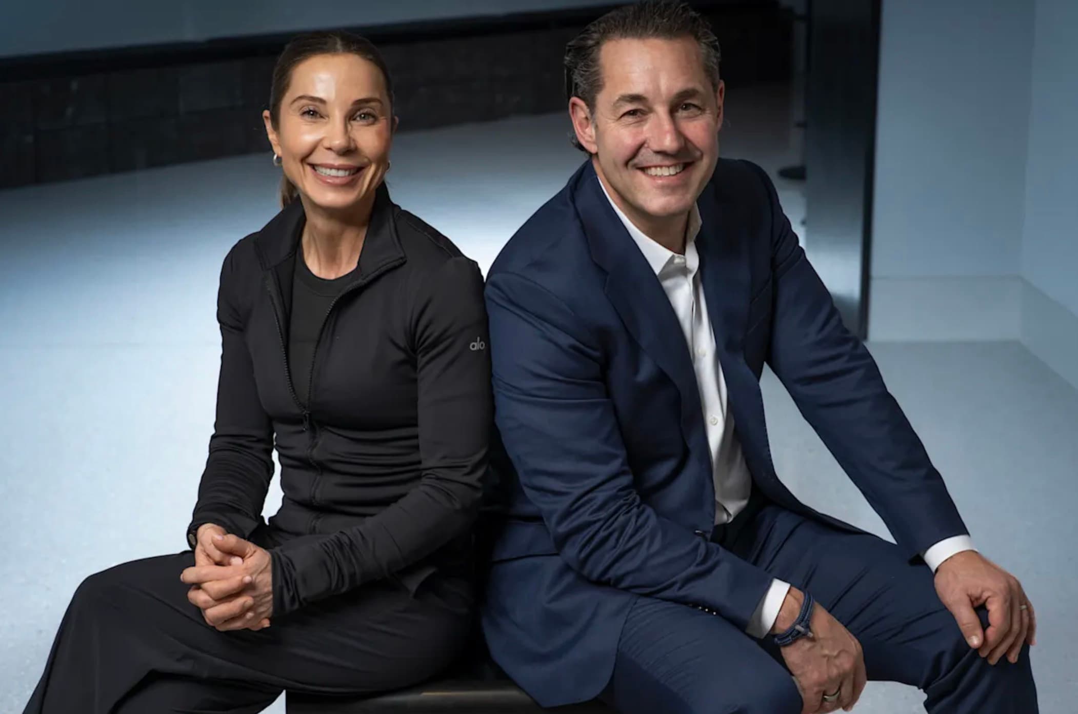 Lorenz Grollo and his wife Manola sitting back to back, smiling