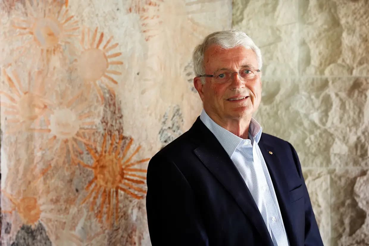 A senior mining industry executive poses for a portrait against a stone wall