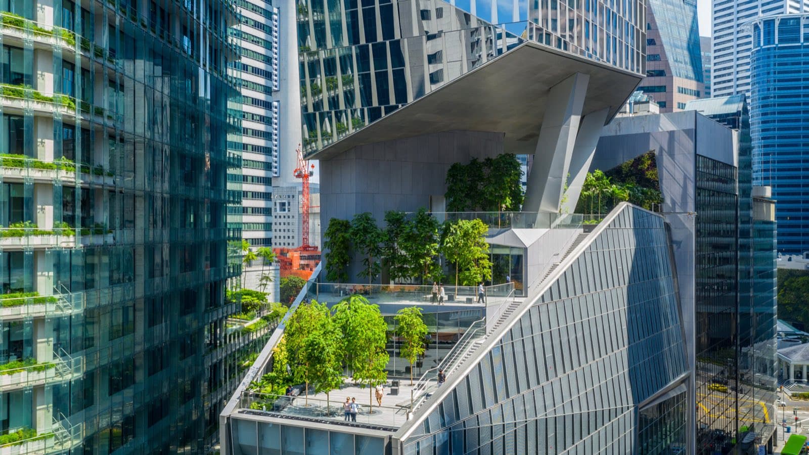 Trees and sky terraces growing across the stepped levels of a skyscraper in Singapore's financial district