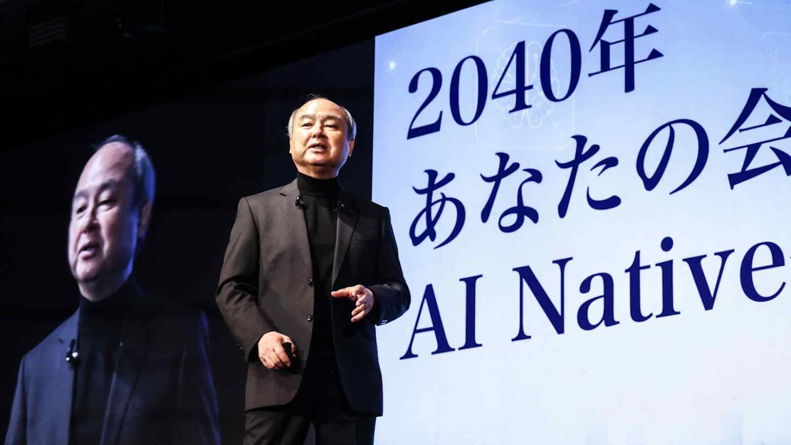 SoftBank founder Masayoshi Son speaks on stage in front of a screen reading AI Native at the SoftBank World event in Tokyo