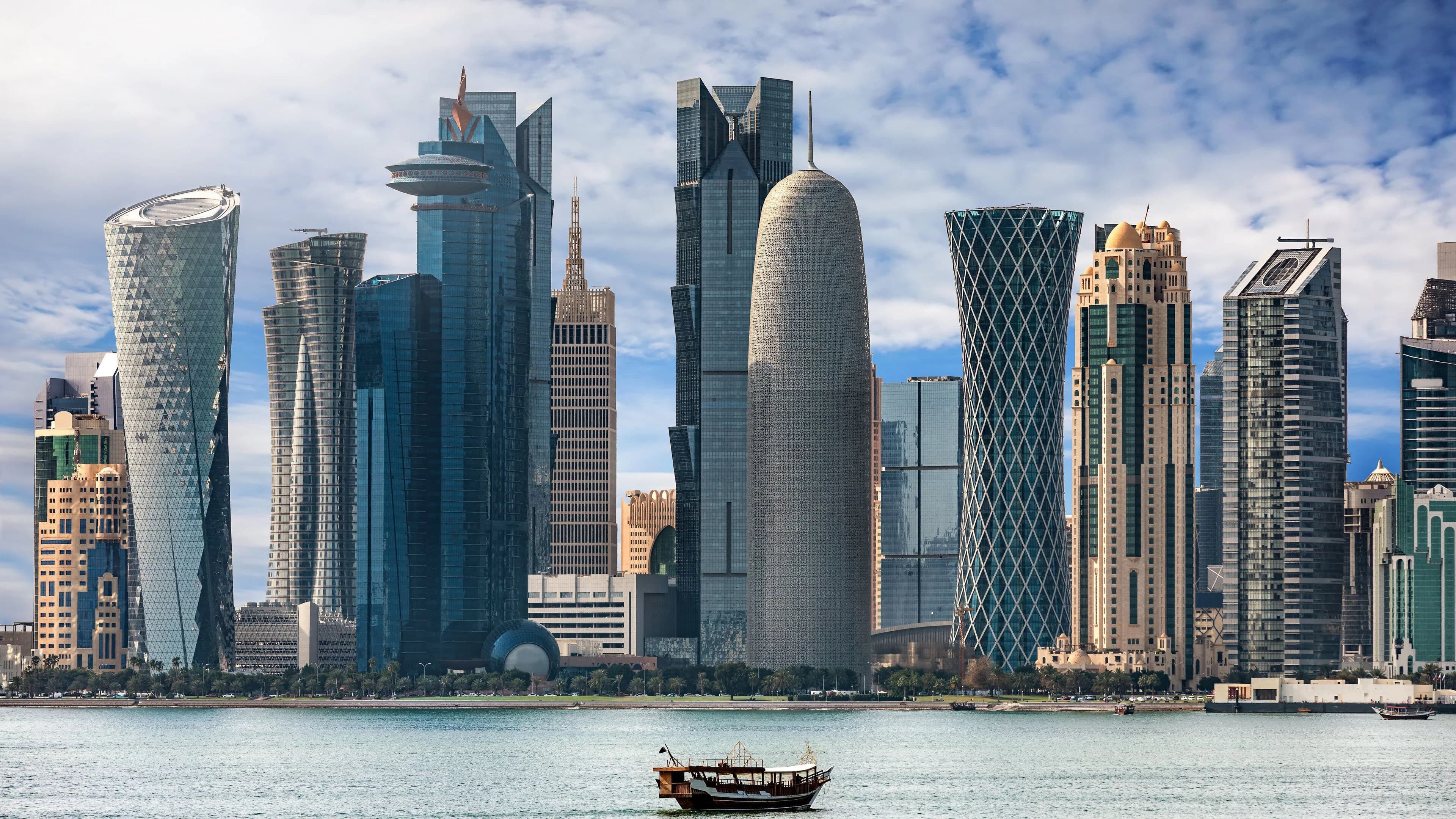 The Doha, Qatar skyline seen from the waterfront with a traditional dhow boat in the foreground