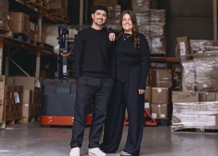 Kasey and Michael Giarratana standing together in a warehouse full of boxes