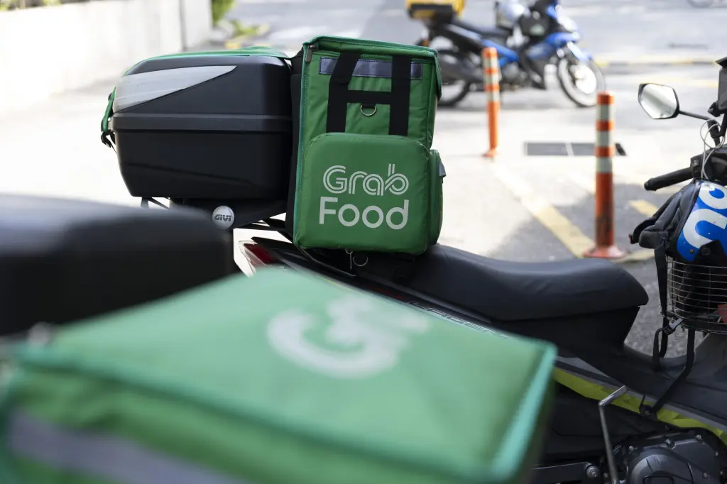 A Grab Food delivery bag mounted on the back of a motorbike