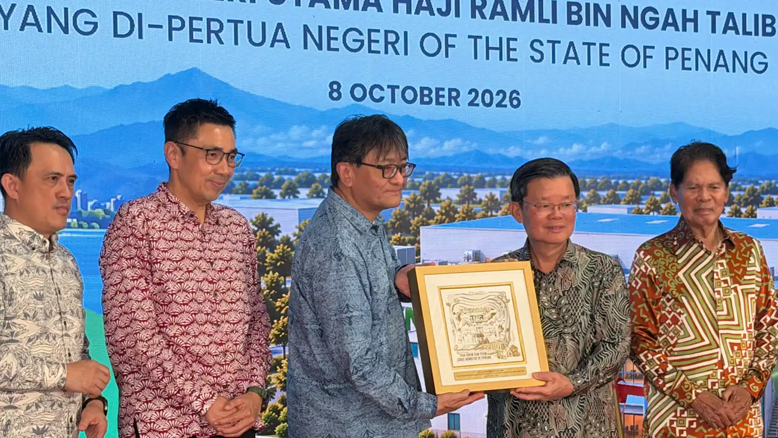 Officials, including Penang's Chief Minister, posing with a commemorative plaque at a ceremony marking the new recycling plant