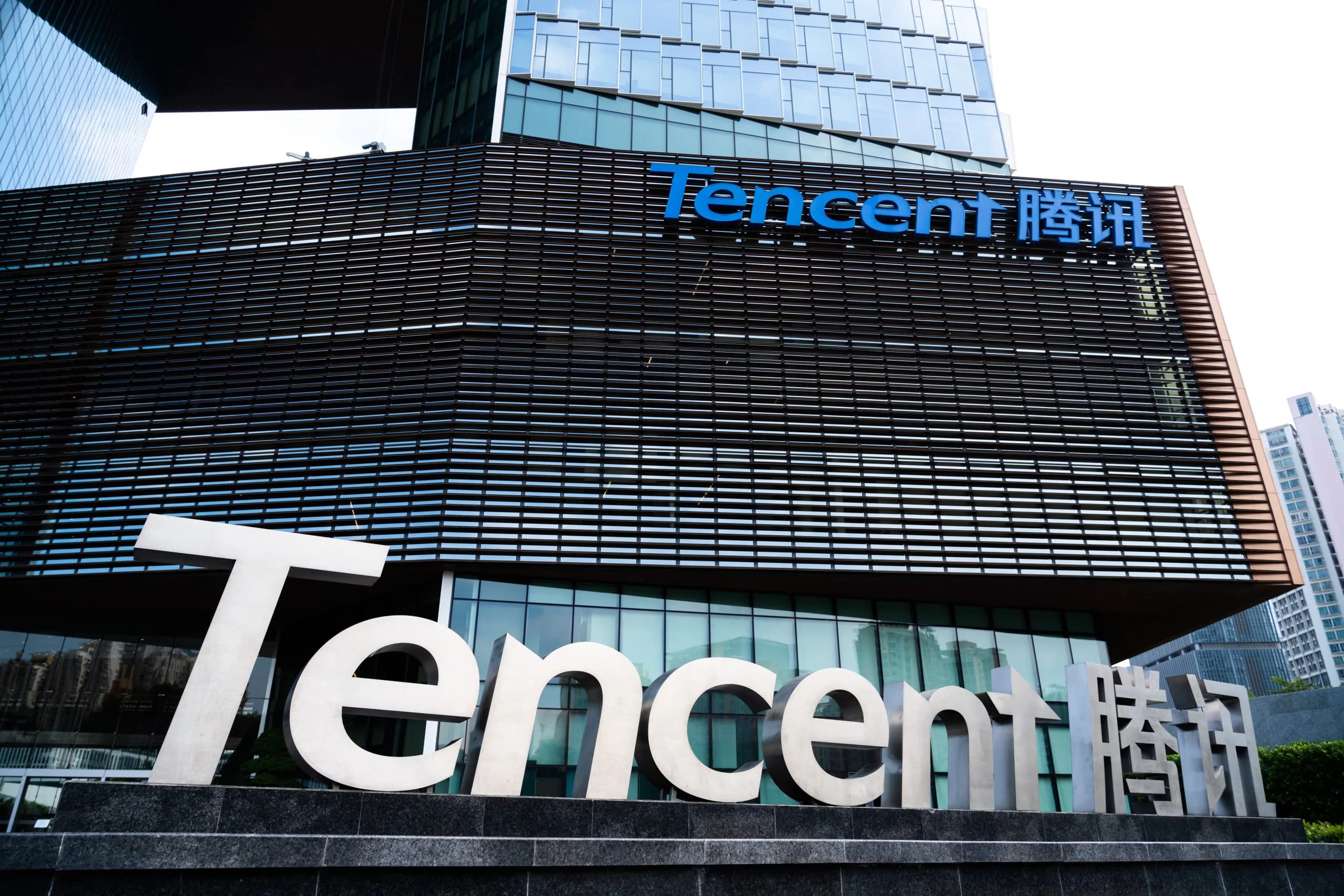 The Tencent logo on the company's headquarters building in Shenzhen, with a large Tencent sculpture in front