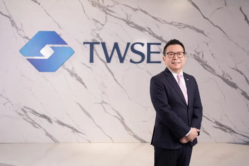 Sherman Lin, chair of the Taiwan Stock Exchange, standing beside the TWSE logo